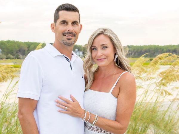 Couple posing outdoors by the marsh.