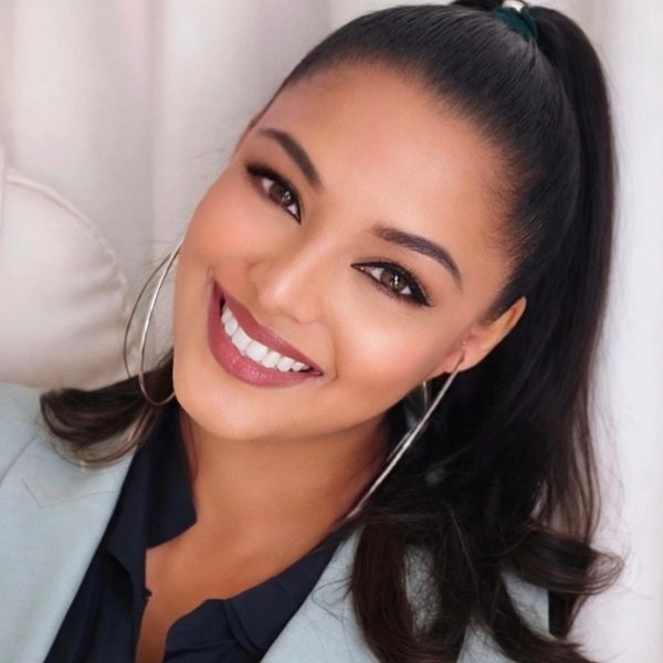 Confident woman with radiant smile and hoop earrings.