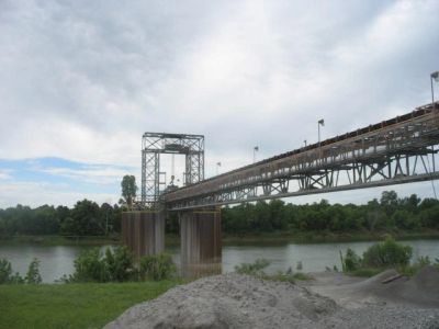 Metal bridge over a river on a cloudy day.