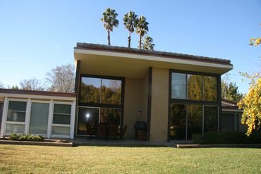 Two-story house with palm trees and lawn