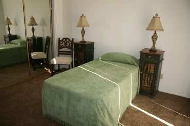 Green bed with two bedside lamps