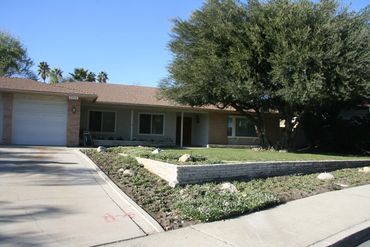 Exterior of a single-story home and tree