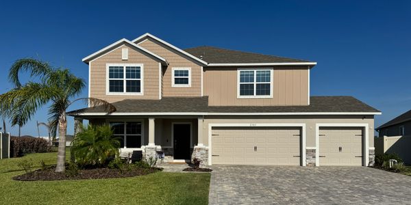 Modern two-story house with a three-car garage and palm trees in the yard.