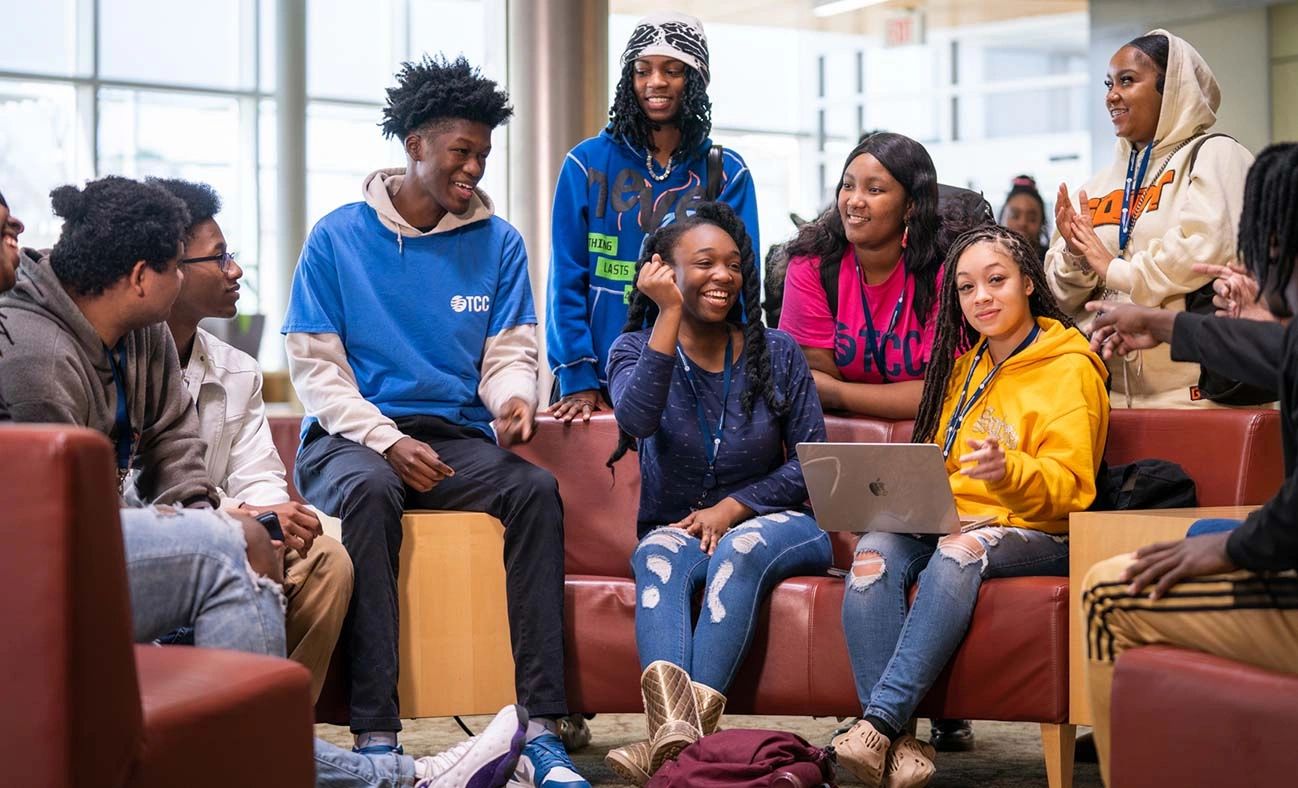 A group of diverse students enjoying a lively discussion in a cozy lounge area.