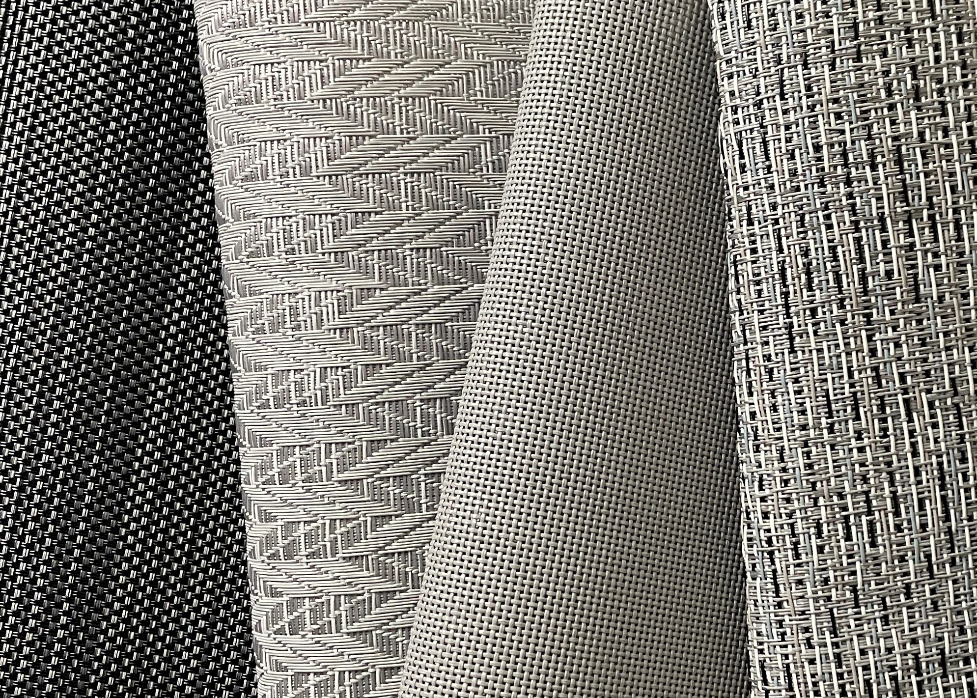 Close-up of different woven fabric textures in black and gray tones.