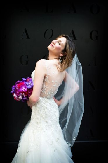 Bride posing for camera with eyes closed smiling