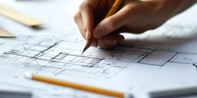 Hand sketching architectural plans with pencil.