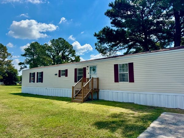Large level lot with parking pad. Three bedrooms, two baths, laundry area, kitchen, and living room.
