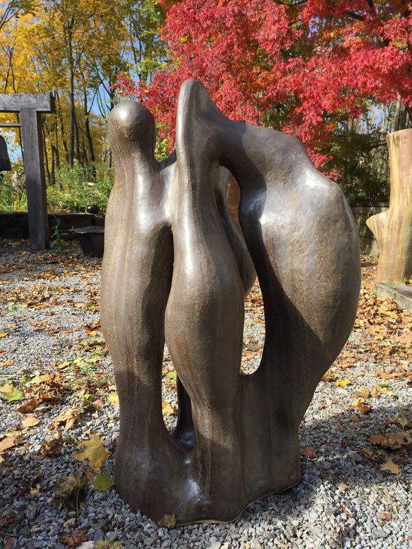 abstract ceramic sculpture in Toshiko Takaezu's courtyard with Japanese maple turning colors
