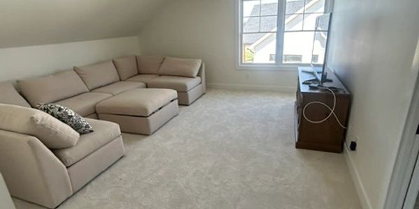 Bright room with beige sectional sofa and TV.