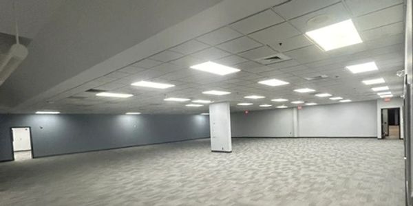 Empty office space with carpet and ceiling lights.