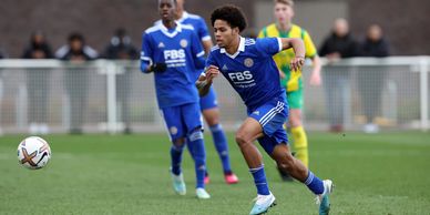 Soccer player in blue kit chasing the ball during a match.