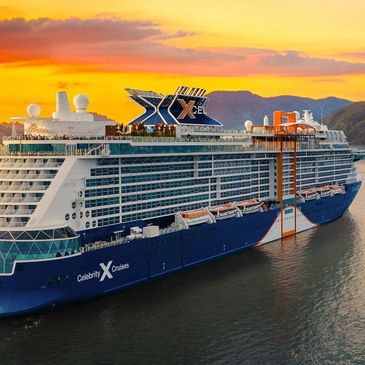 Celebrity Cruises ship at sunset by the coast.