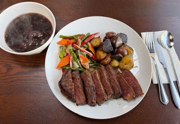 Beef steak with assorted vegetables and potatoes, pork trotter with black bean soup