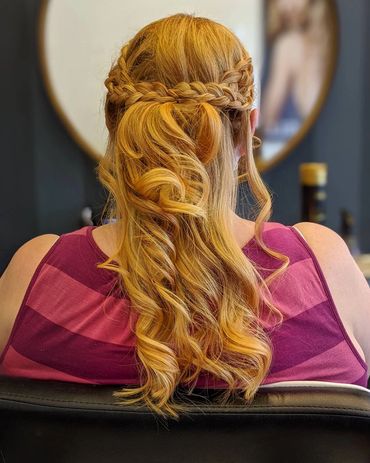 Half-up braided hairstyle with soft curls, created at Santoro Hair Salon in Brighton.