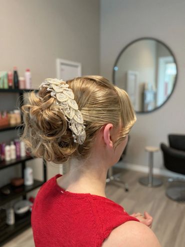 Elegant bridal bun with soft twists and a pearl-embellished hairpiece, styled at Santoro Hair Salon 