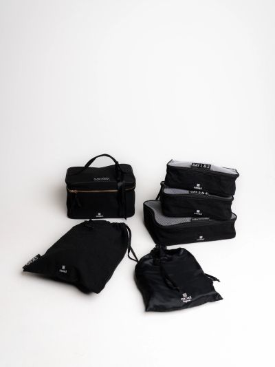 Set of black travel organizers and pouches neatly arranged.