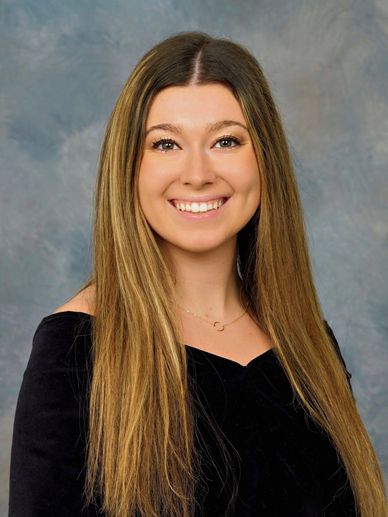 Young woman with long hair smiling in a portrait.