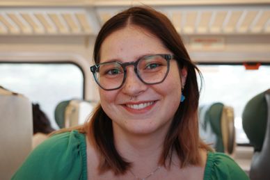 Smiling woman wearing glasses on a train.