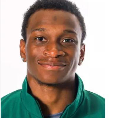 Young man smiling in a green jacket against a white background.