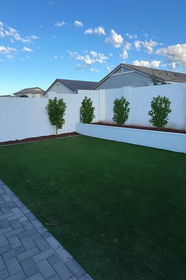 backyard landscape with pavers, retaining wall and turf in Arizona 