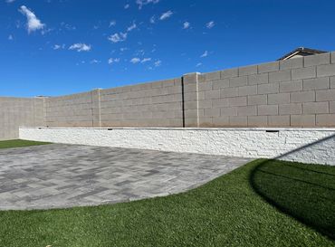backyard landscape with pavers, retaining wall and turf in Arizona 