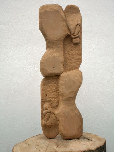 Abstract wooden sculpture with rounded shapes.