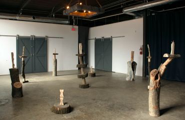 Wood sculptures displayed in an art gallery.