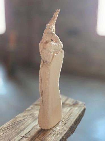 Abstract wooden sculpture on a wooden surface.