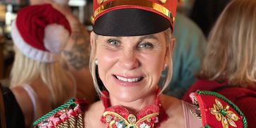 Woman smiling in festive holiday attire.
