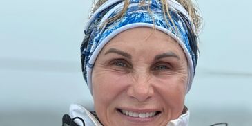 Smiling woman outdoors in cold weather gear.