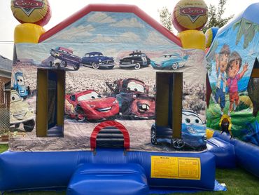 Caines Castles cars themed bouncy castle next to dora bouncy castle