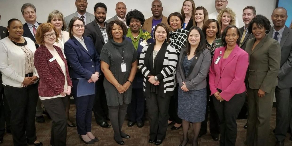 A diverse group of professionals posing together in an office setting.