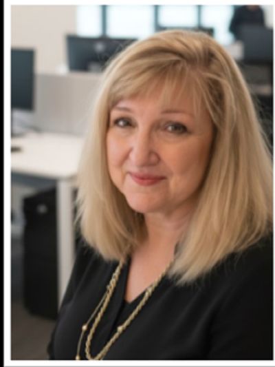 Smiling woman with blonde hair in an office.