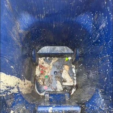 Inside view of a dirty blue trash bin.