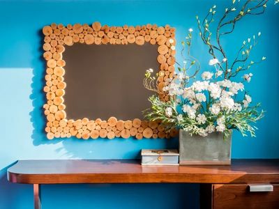 Wood-framed chalkboard with floral arrangement on desk.