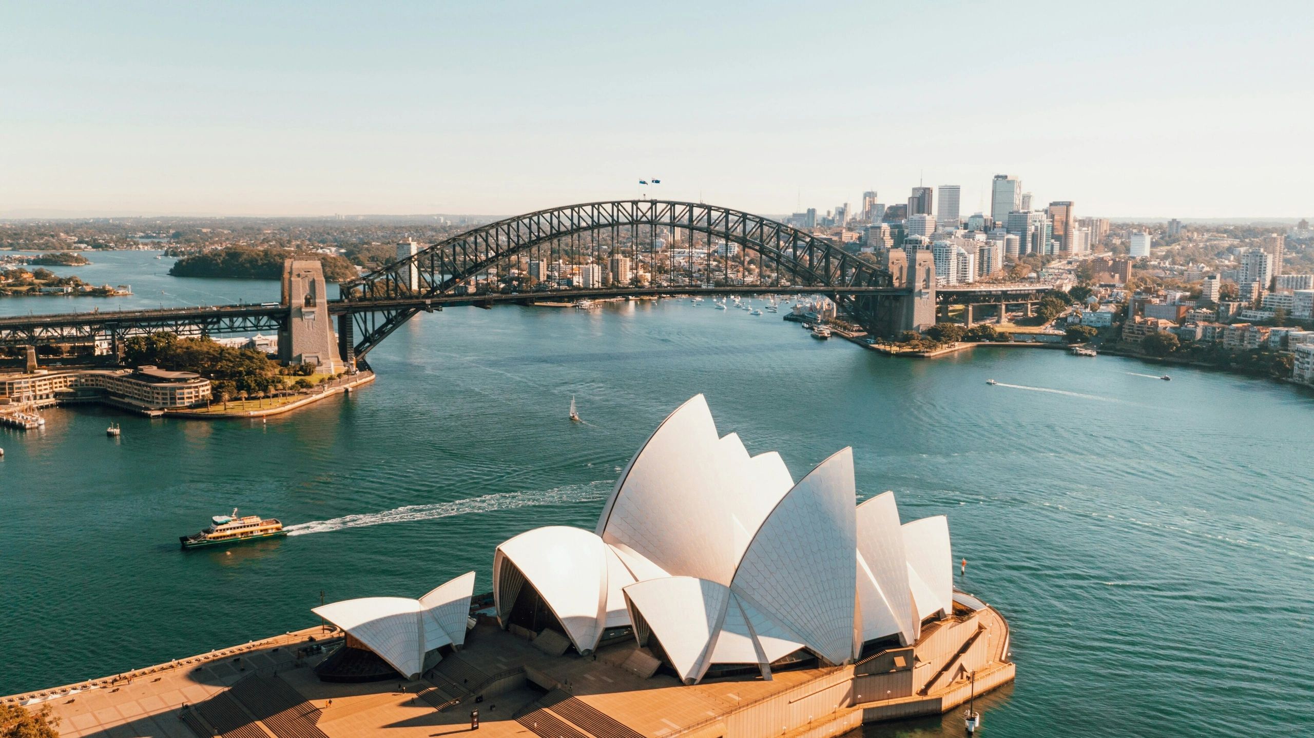 Sydney Opera House with Harbour Bridge and city skyline in the background.