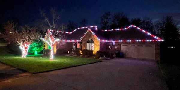 House decorated with red, white, and green lights at night.