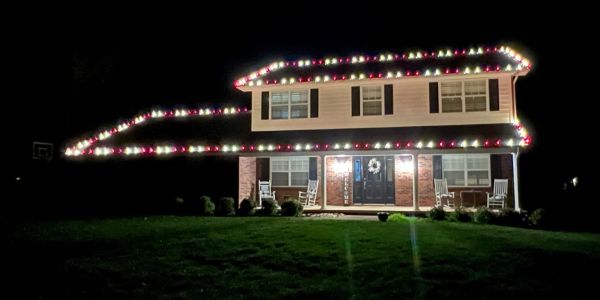 House decorated with colorful Christmas lights at night.