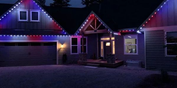 House decorated with red, white, and blue lights at night.