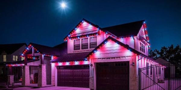 House decorated with red and blue lights at night.