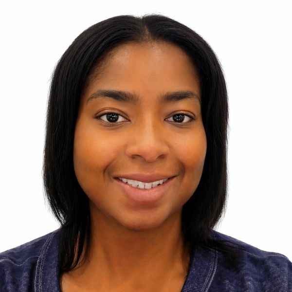 Portrait of a smiling woman with straight black hair and a navy top.