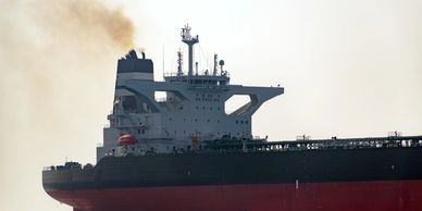 Navio a óleo emitindo fumaça no céu.