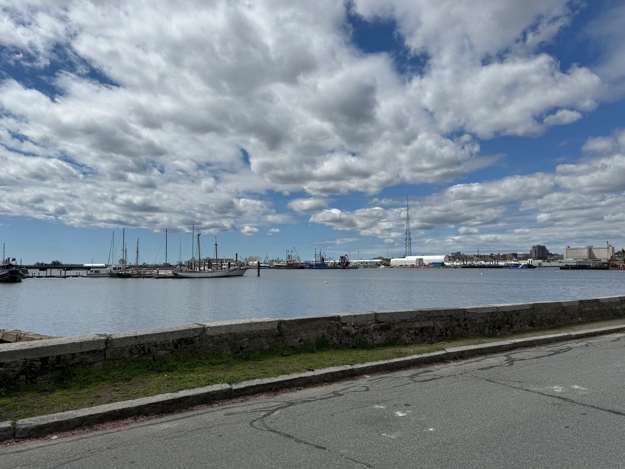 Harbor with boats under cloudy sky.
