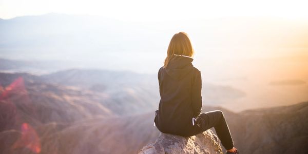 Women sitting on cliff looking out into the distance