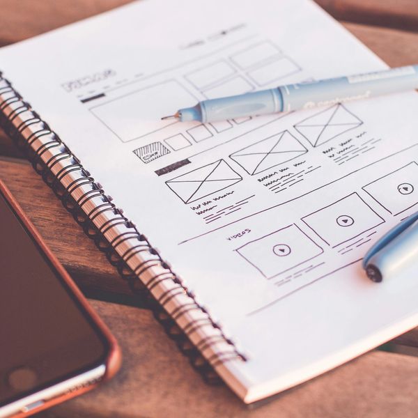 Notebook with web design sketches, highlighting the initial stages of layout and UI planning.