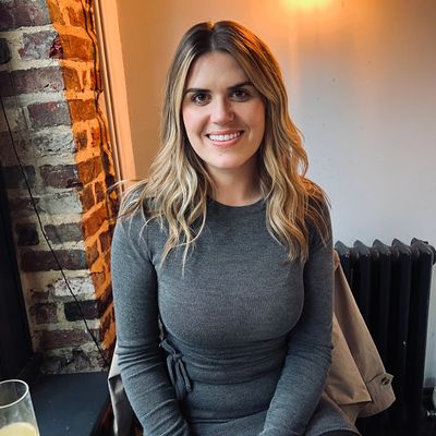 Woman smiling at the camera in a cozy setting.