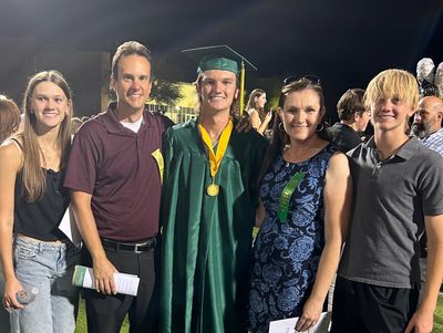 Family celebrating graduation night outdoors.