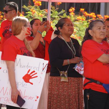 People at a protest holding signs about murdered people and justice.