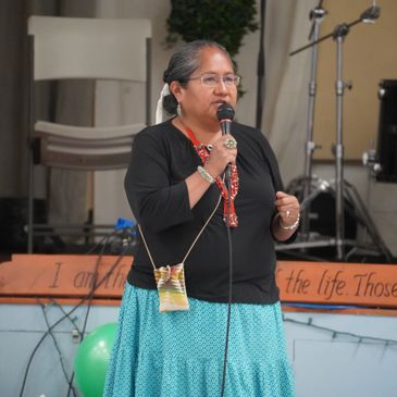 A woman speaking into a microphone during an event.